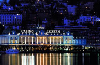Beleuchtete Fassade des Grand Casino Luzern bei Nacht mit Spiegelung im Vierwaldstättersee
