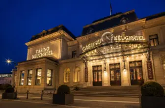 Beleuchtete Fassade des Casino Neuchâtel in der Abenddämmerung