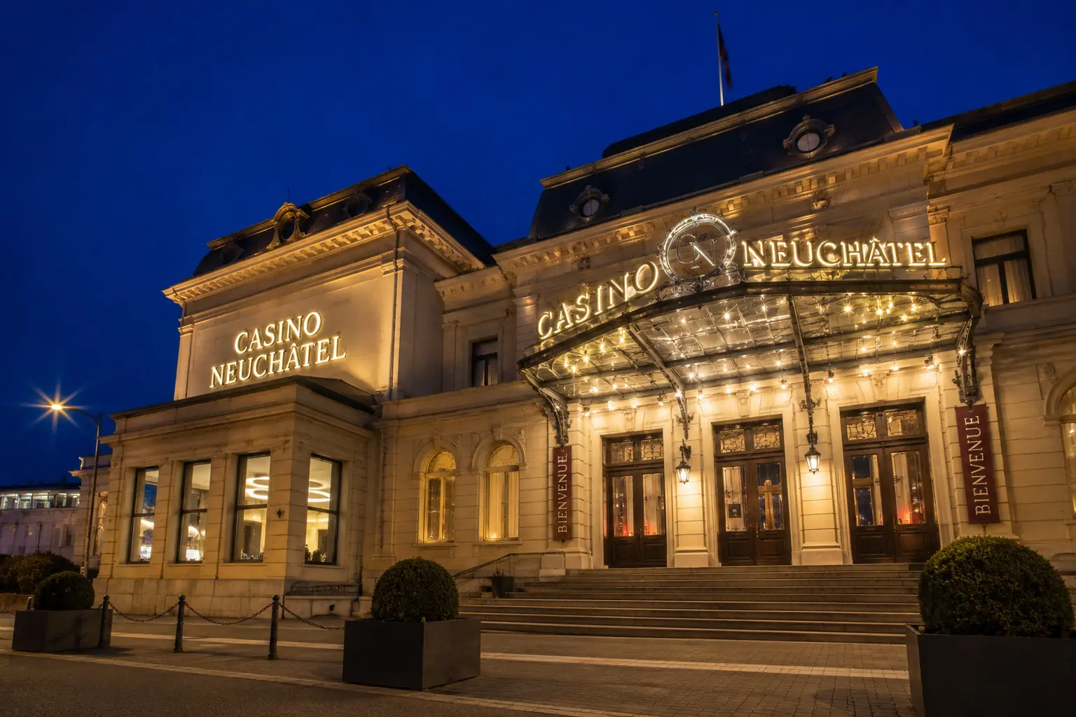 Beleuchtete Fassade des Casino Neuchâtel in der Abenddämmerung