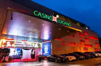 Beleuchteter Eingang des Casinò Lugano bei Nacht mit Schriftzug