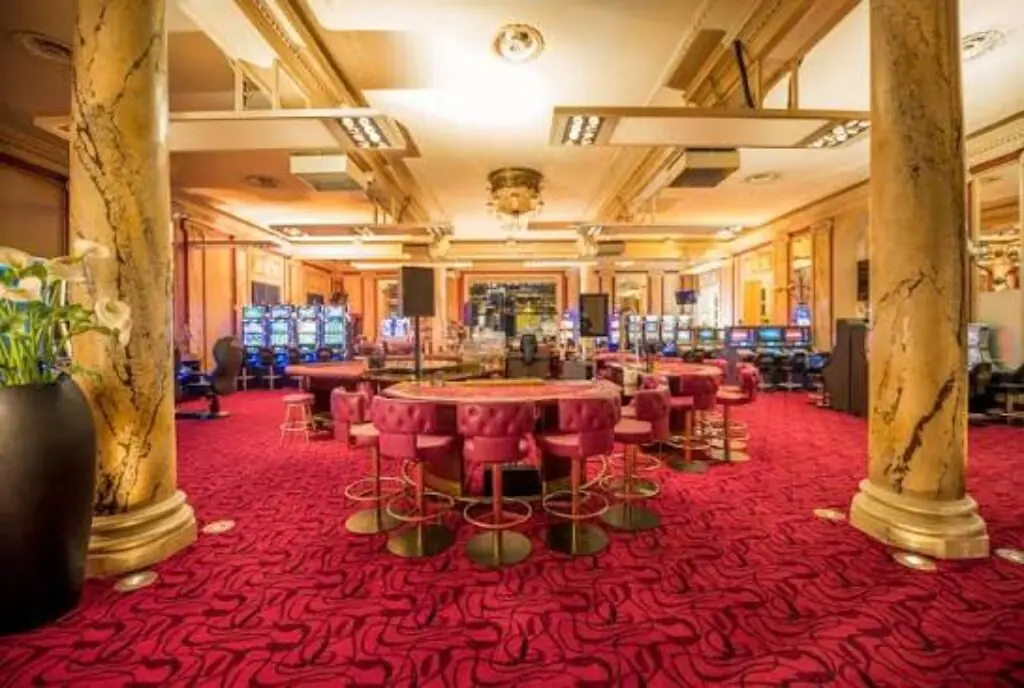 Klassischer Spielsaal mit Säulen und rotem Teppich im Grand Casino Luzern
