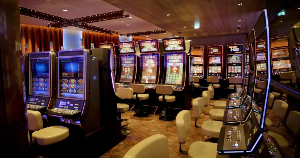 Reihe von Spielautomaten mit Sesseln im Spielsaal des Casino Schaanwald
