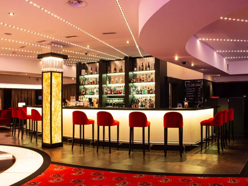 Bar mit roten Barhockern und Flaschenwand im Casino St. Gallen