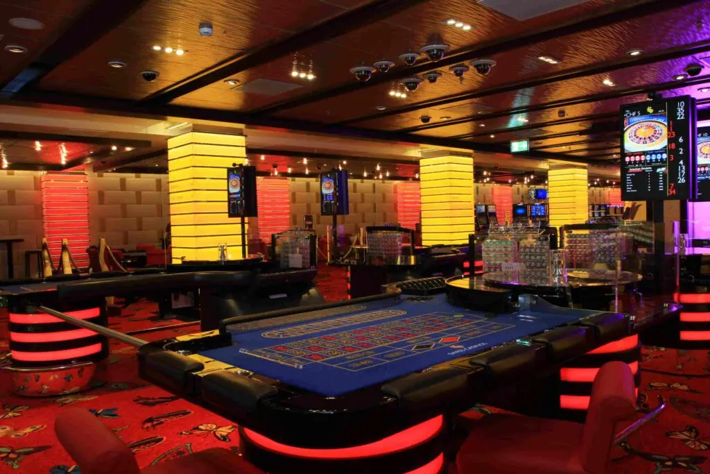 Spieltisch mit blauem Filz und beleuchteter Wand in den Swiss Casinos Zürich